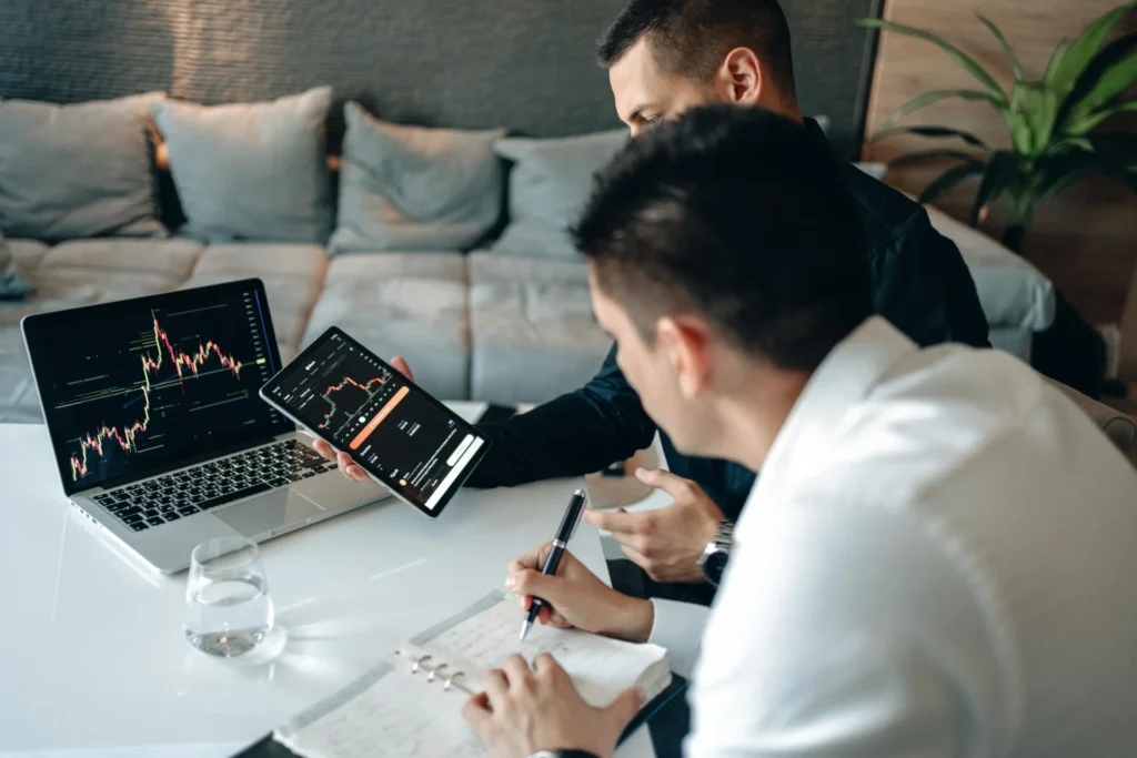 Investigador de mercado utilizando computadora y tablet para analizar datos y apoyar decisiones en el sector industrial