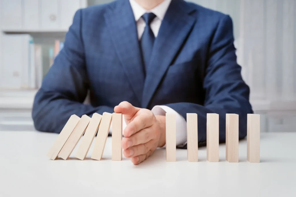 Ejecutivo en traje analizando riesgos y oportunidades con fichas de dominó