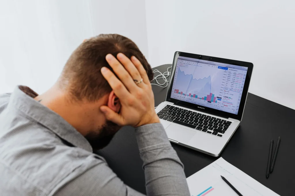 Persona mostrando desesperación frente a la computadora al visualizar la caída de ventas y pérdidas de clientes